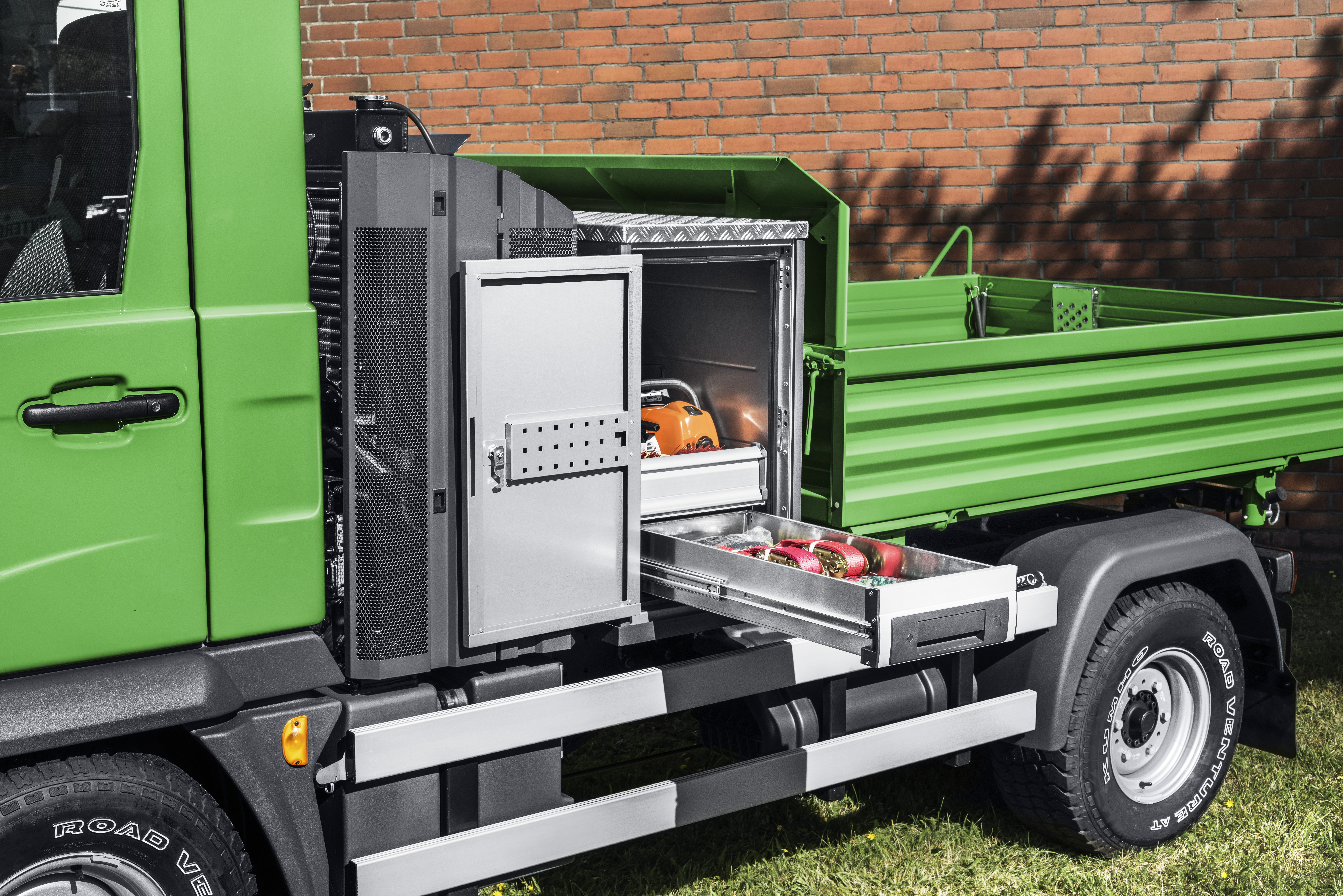 Grüner Multicar mit bottTainer vor vollem Pritschenaufsatz gefüllt mit Werkzeugen und ausgezogener Schublade.